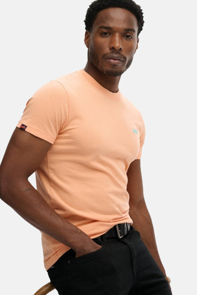 T-shirt orange à manches courtes de SUPERDRY, porté avec un jean noir et une ceinture à boucle.