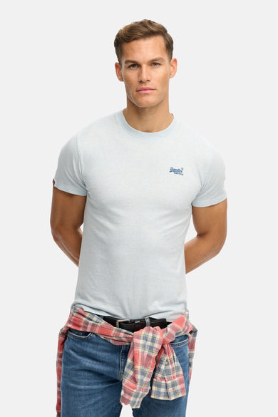 T-shirt à manches courtes bleu clair de SUPERDRY, porté avec une chemise à carreaux nouée à la taille.