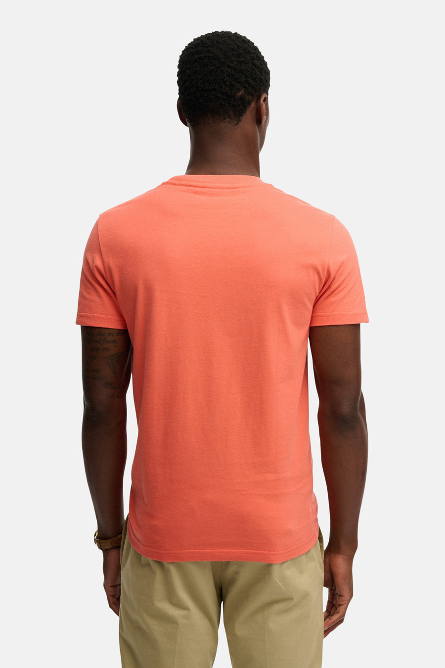 Koraalkleurig T-shirt met korte mouwen van SUPERDRY, effen model van tricot op een man van achteren gezien.