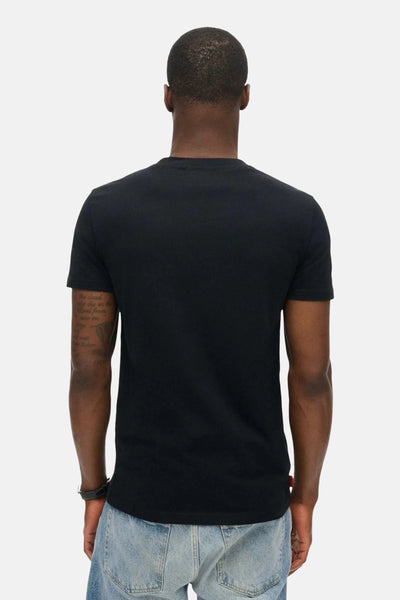 T-shirt à manches courtes noir de SUPERDRY, porté avec un jean bleu clair, vue de dos.