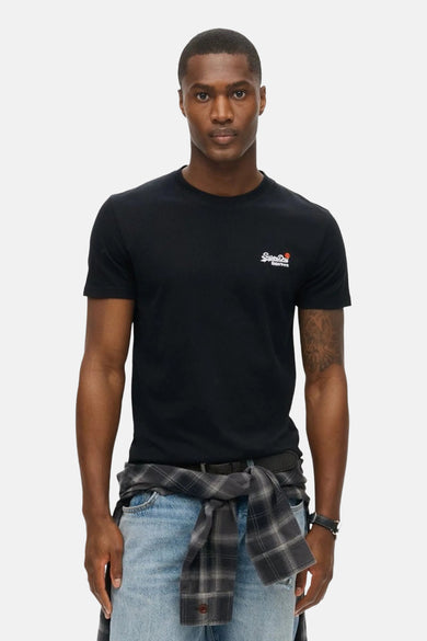 T-shirt noir à manches courtes de SUPERDRY avec logo brodé sur la poitrine, porté avec une chemise à carreaux nouée.
