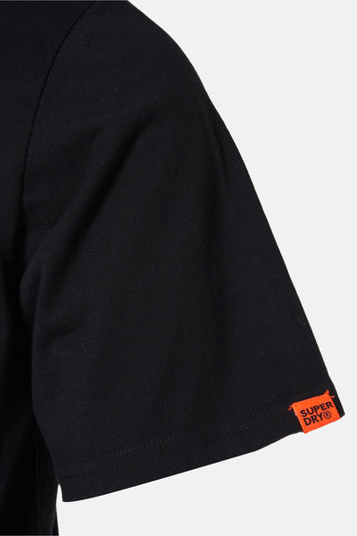 T-shirt noir à manches courtes de SUPERDRY, avec une petite étiquette orange sur la manche.