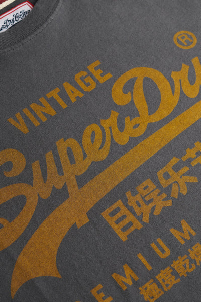 T-shirt à manches courtes gris de Superdry, avec imprimé graphique jaune vintage sur le devant.