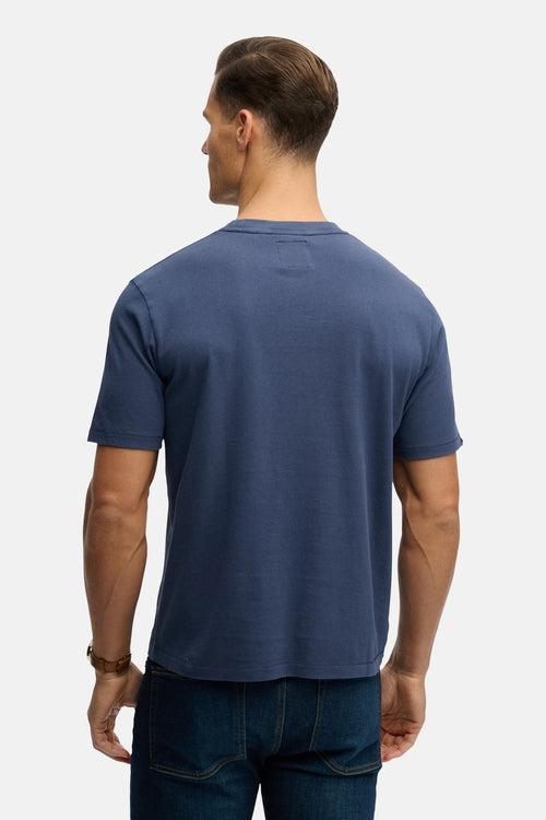 T-shirt à manches courtes bleu de SUPERDRY, vu de dos, porté avec un jean foncé.