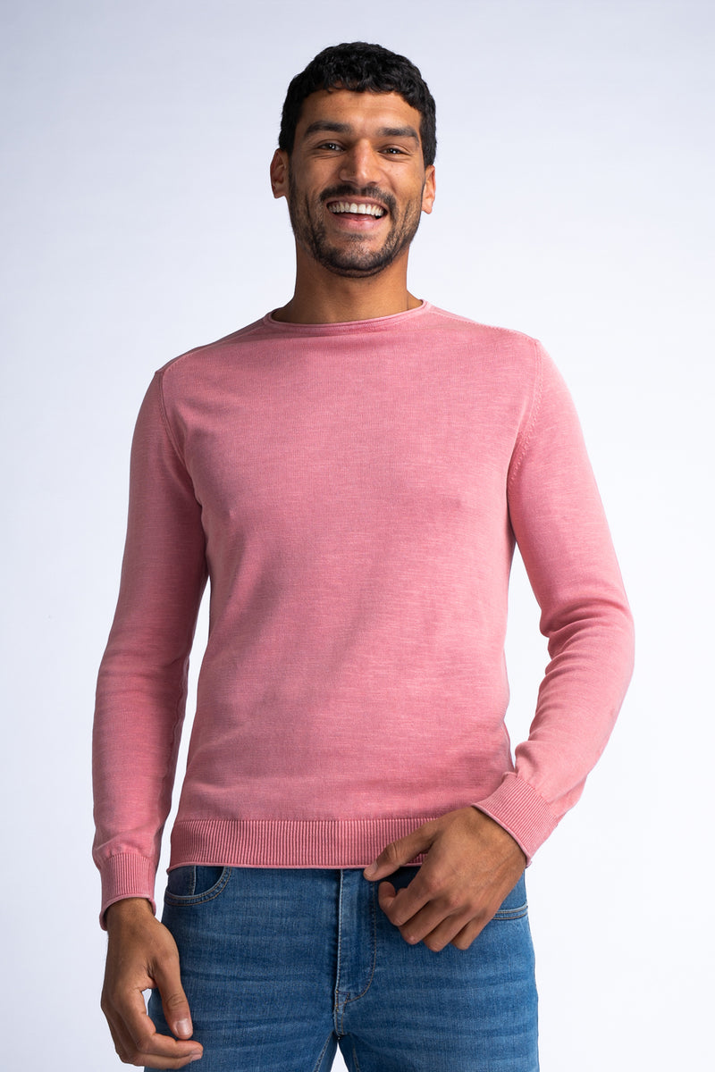 Pull rouge à col rond de Petrol Industries, porté avec un jean bleu.
