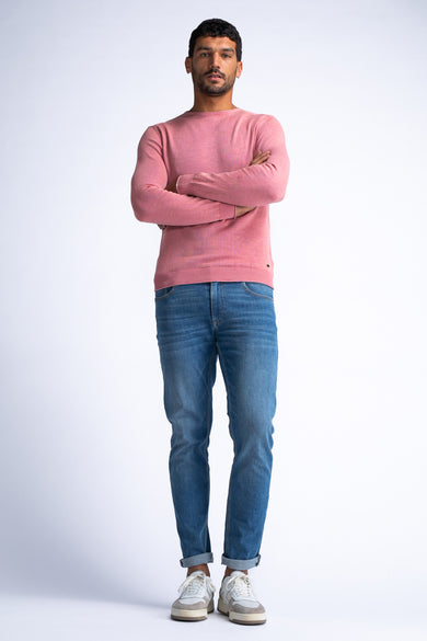 Pull rouge col rond de Petrol Industries®, porté avec un jean bleu et des baskets blanches.
