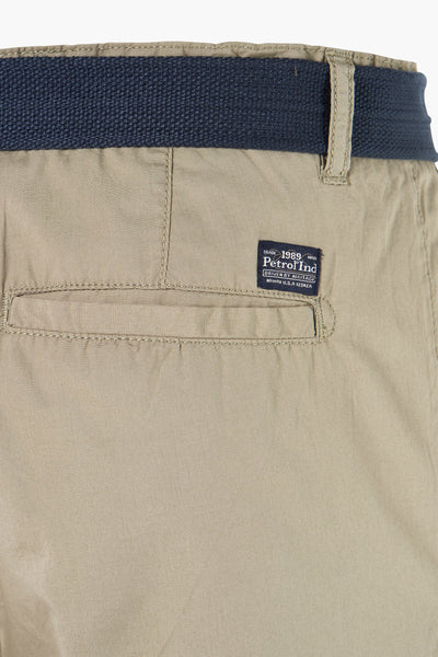 Beige bermuda van Petrol Industries met marineblauwe riem, paspelzak achter en merklabel.