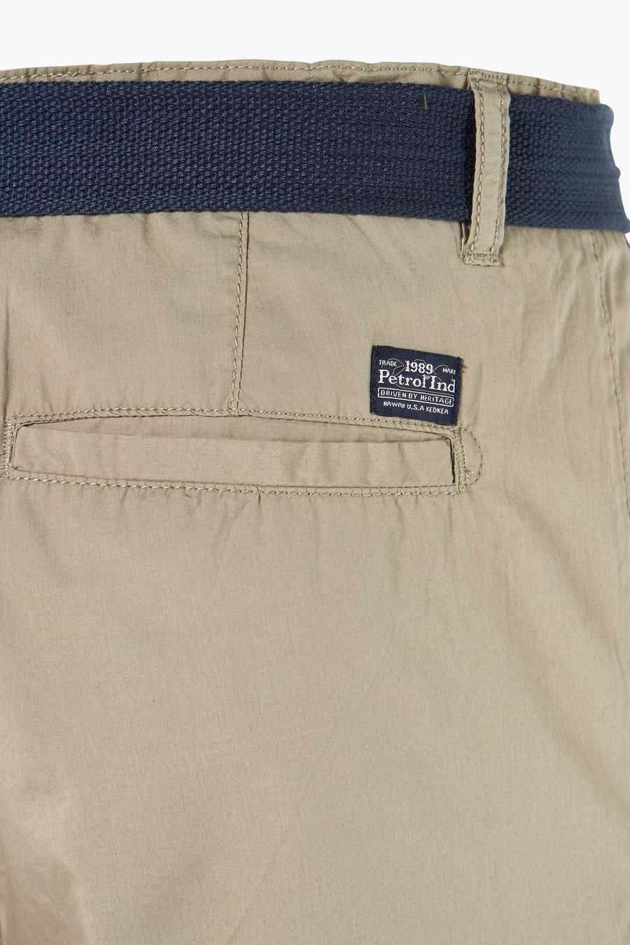 Beige Bermuda van Petrol Industries met marineblauwe riem, paspelzak achter en merklabel.