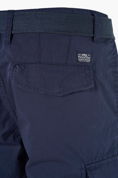 Blauwe bermuda van Petrol Industries, met een cargozak op het been en een bijpassende riem.