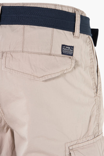 Bermuda beige par Petrol Industries, avec ceinture bleu marine et poche arrière boutonnée.
