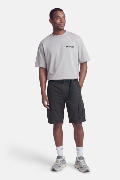 Bermuda bleu de Petrol Industries, avec poches cargo et une ceinture foncée, porté avec un t-shirt gris.