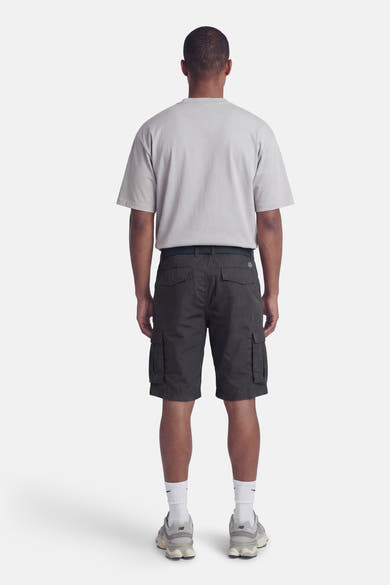 Bermuda bleu de Petrol Industries®, porté avec un t-shirt gris, des chaussettes blanches et des baskets grises.