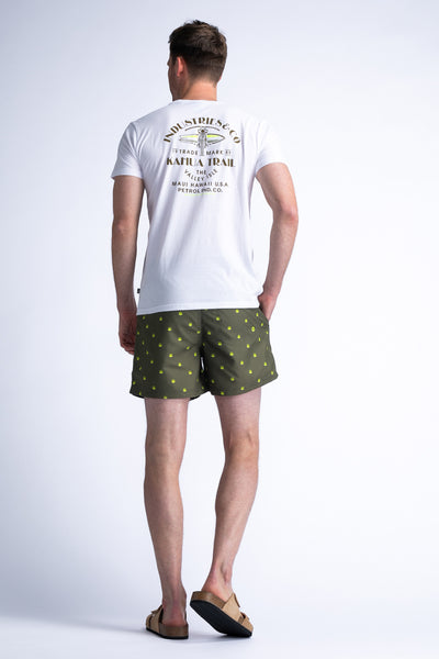 Short de bain vert à motifs, de Petrol Industries®, porté avec un t-shirt blanc et des sandales.
