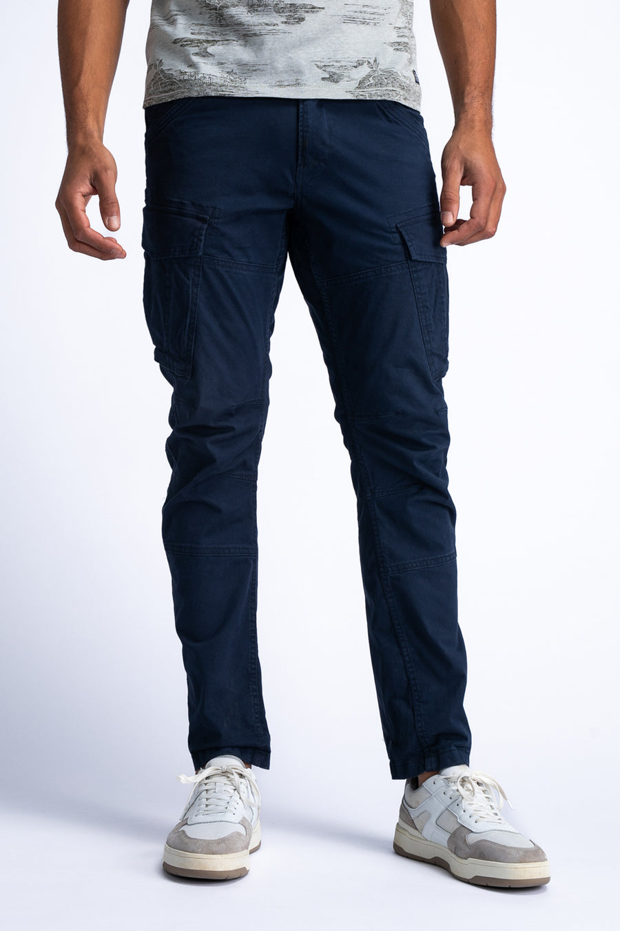 Blauwe cargobroek van Petrol Industries®, gedragen met een T-shirt met opdruk en witte sneakers.