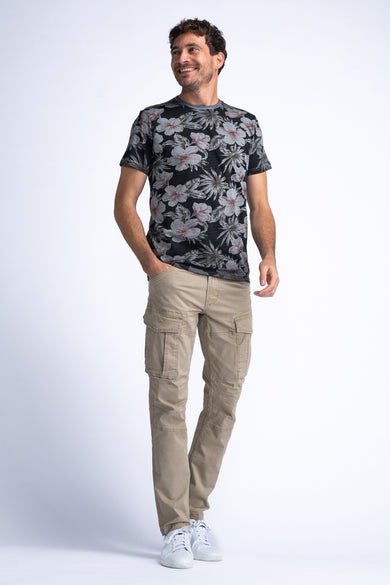 Beige cargobroek van Petrol Industries, gedragen met een T-shirt met bloemenprint en witte sneakers.