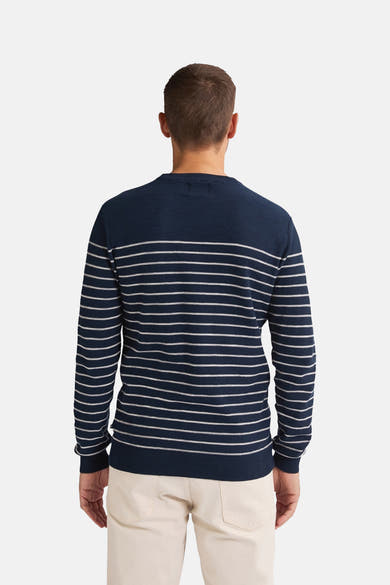 Ronde hals trui blauw van Petrol Industries, met witte horizontale strepen, gedragen met een beige broek.