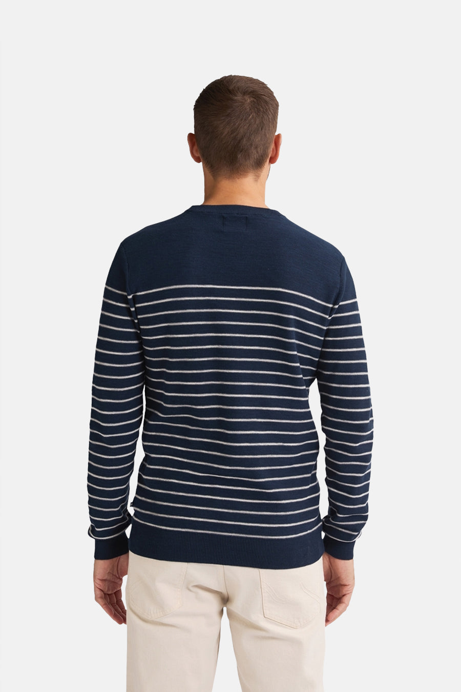 Ronde hals trui blauw van Petrol Industries, met witte horizontale strepen, gedragen met een beige broek.