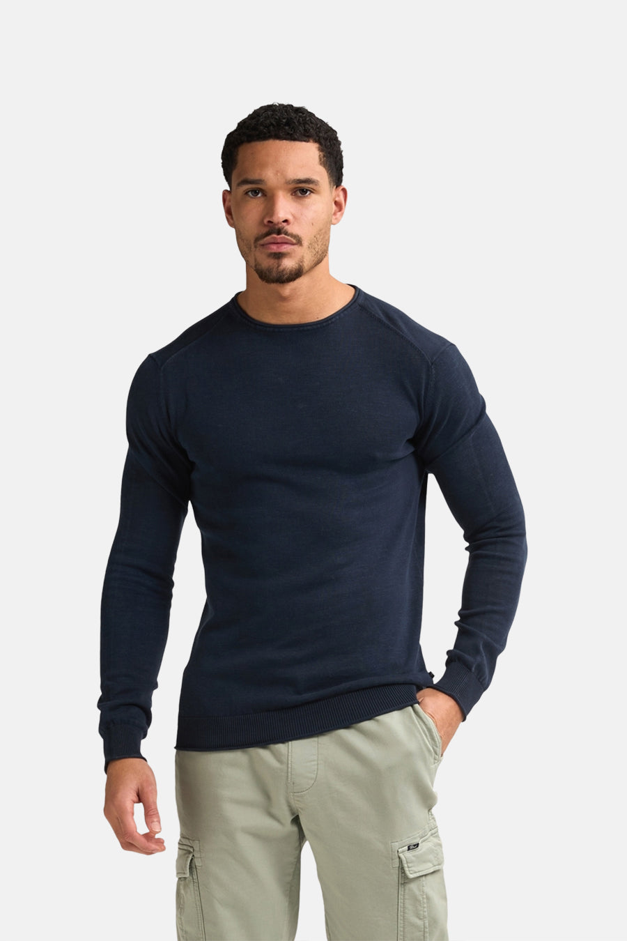 Pull à col rond bleu de Petrol Industries, porté avec un pantalon cargo kaki.