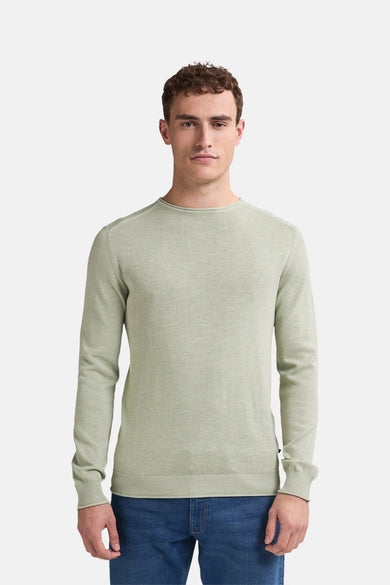 Pull à col rond vert de Petrol Industries, porté avec un jean bleu uni.