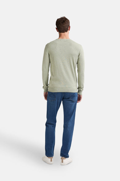 Pull à col rond vert de Petrol Industries, porté avec un jean bleu et des baskets blanches, vue de dos.
