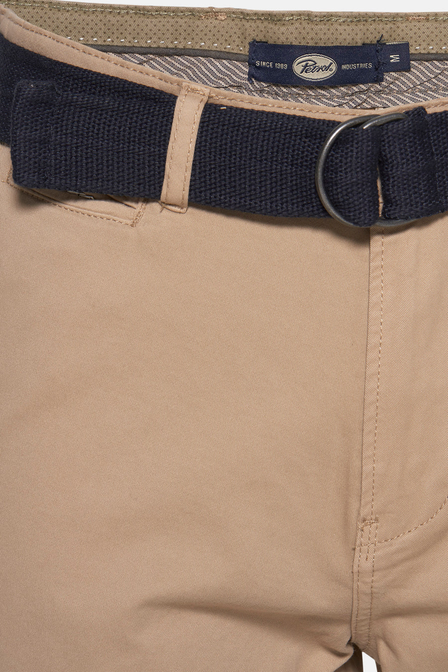 Korte beige short van Petrol Industries, met marineblauwe riem en zilveren gesp, met zichtbare voorzak.