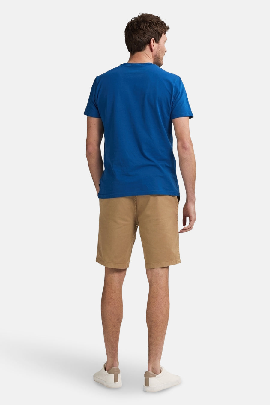 Korte beige short van Petrol Industries®, gedragen met een blauw T-shirt en witte schoenen, van achteren gezien.