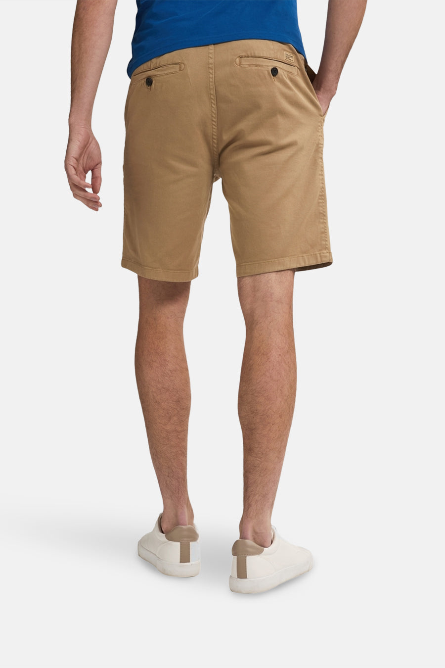 Korte beige short van Petrol Industries, met achterzakken met knopen en witte schoenen.