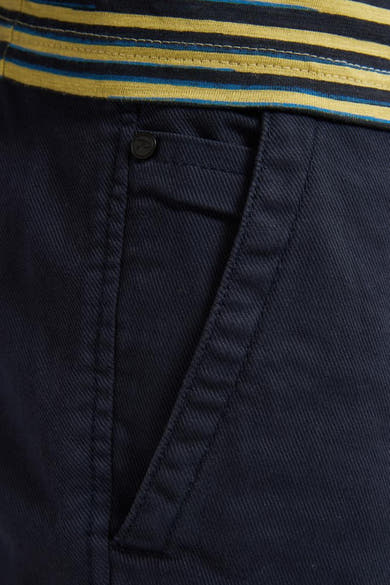 Korte blauwe spijkerjas van Petrol Industries, detail van een schuine voorzak en gele strepen aan de bovenkant.