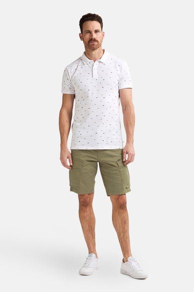 Korte kaki van Petrol Industries, gedragen met een wit poloshirt met patroon en witte sneakers.