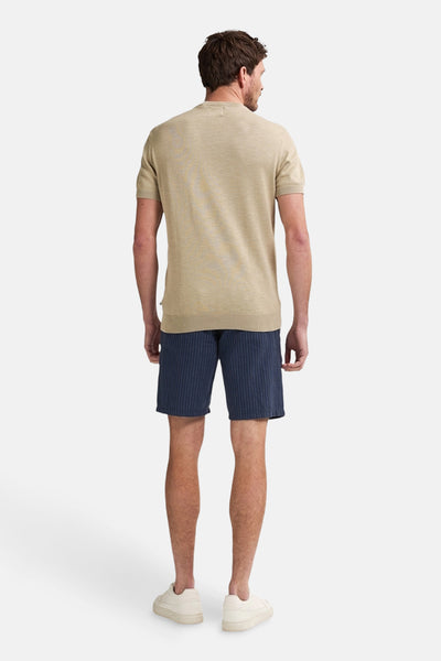 Korte blauwe broek met verticale strepen van Petrol Industries, gedragen met een beige T-shirt en crèmekleurige sneakers.