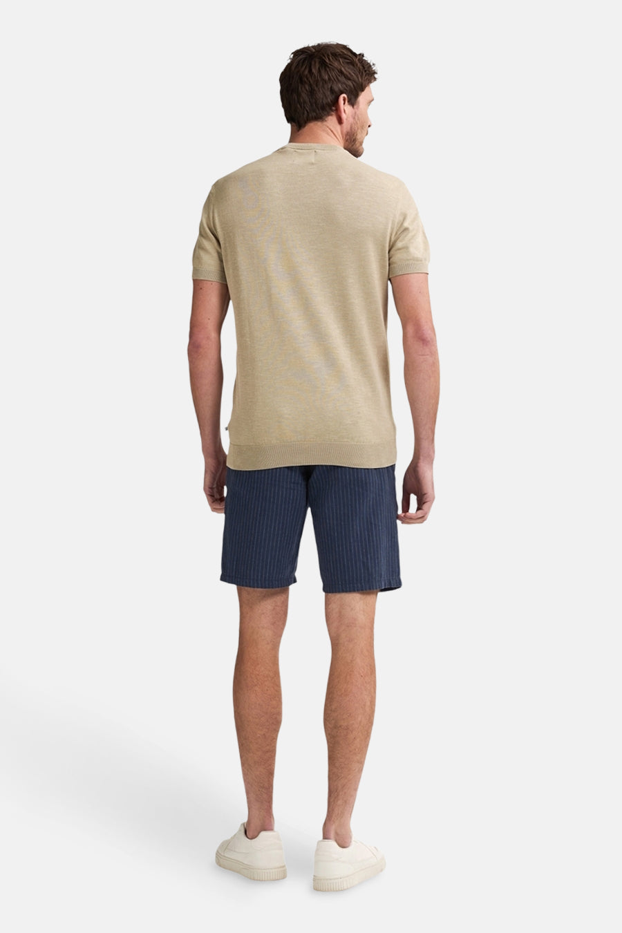 Short bleu à rayures verticales par Petrol Industries, porté avec un t-shirt beige et des baskets crème.