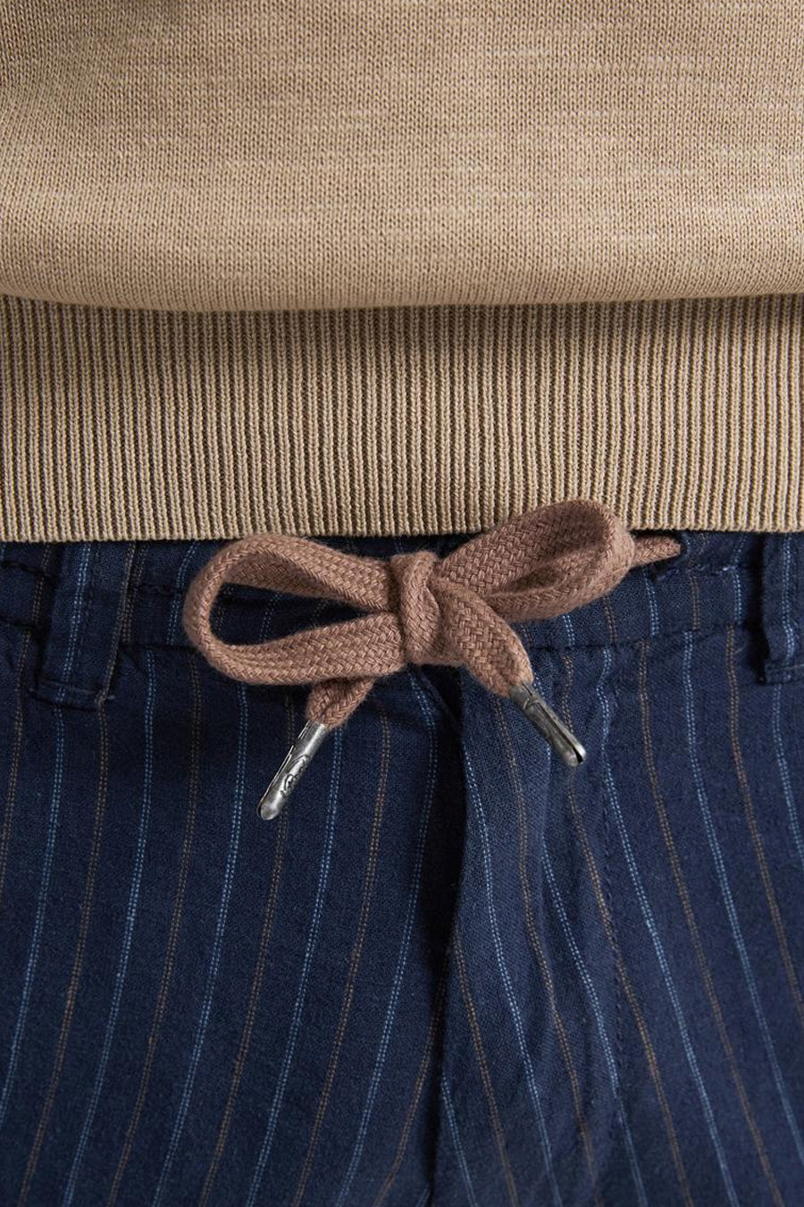 Short bleu à rayures, par Petrol Industries, avec cordon de serrage marron noué.
