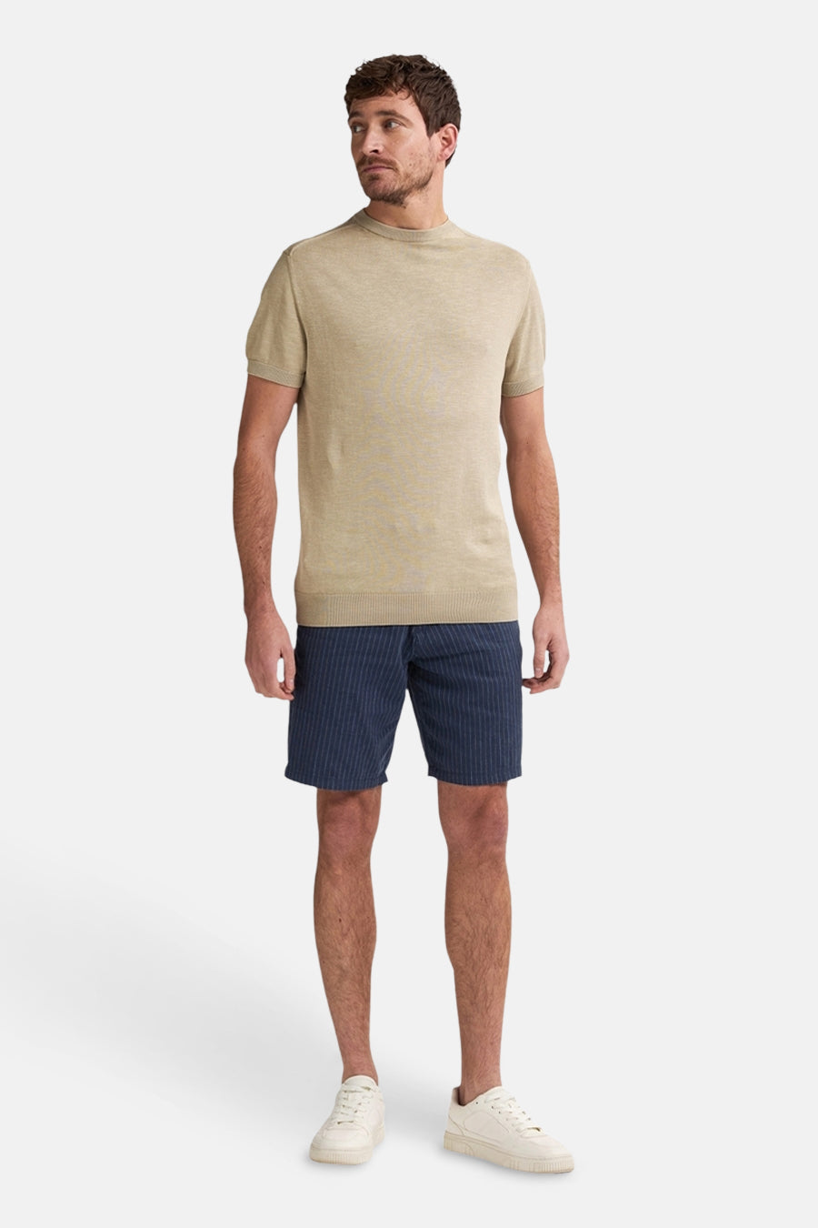Short bleu à rayures verticales by Petrol Industries, porté avec un t-shirt beige et des baskets blanches.