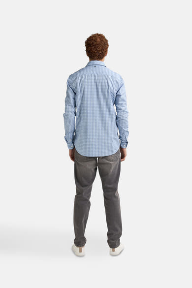 Blauw overhemd met lange mouwen van Petrol Industries, met een geometrisch patroon, gedragen met een grijze jeans en witte sneakers, van achteren gezien.