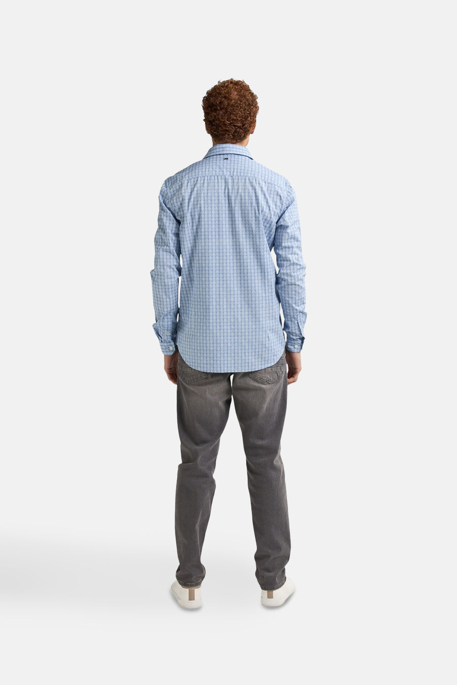 Blauw overhemd met lange mouwen van Petrol Industries, met een geometrisch patroon, gedragen met een grijze jeans en witte sneakers, van achteren gezien.