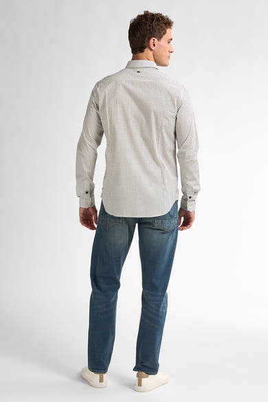 Wit overhemd met lange mouwen en zwarte stippen van Petrol Industries, gedragen met een blauwe jeans en witte sneakers.