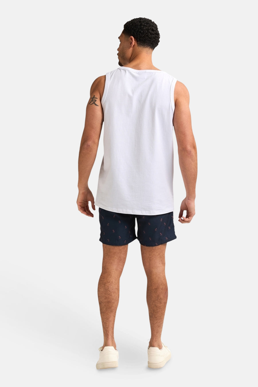 Short de bain bleu foncé de Petrol Industries, avec motif discret, porté avec un débardeur blanc et des baskets.