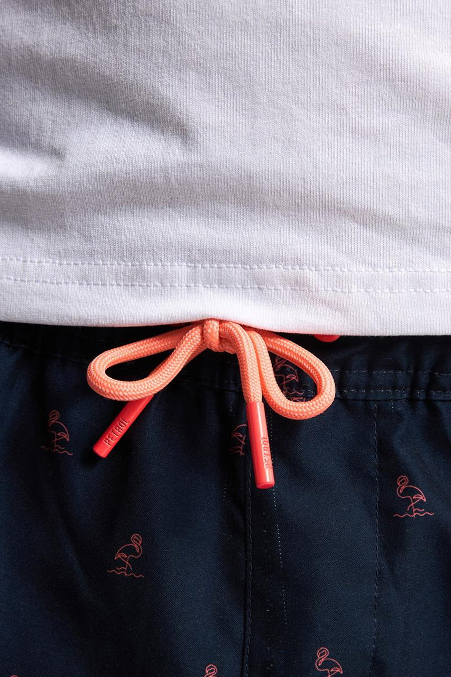 Short de bain bleu foncé de Petrol Industries, à motif flamants roses corail et cordon de serrage corail.
