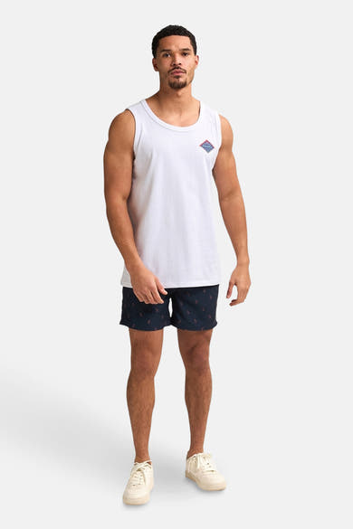 Short de bain bleu foncé de Petrol Industries, à motif d'ancres, porté avec un débardeur blanc et des chaussures blanches.