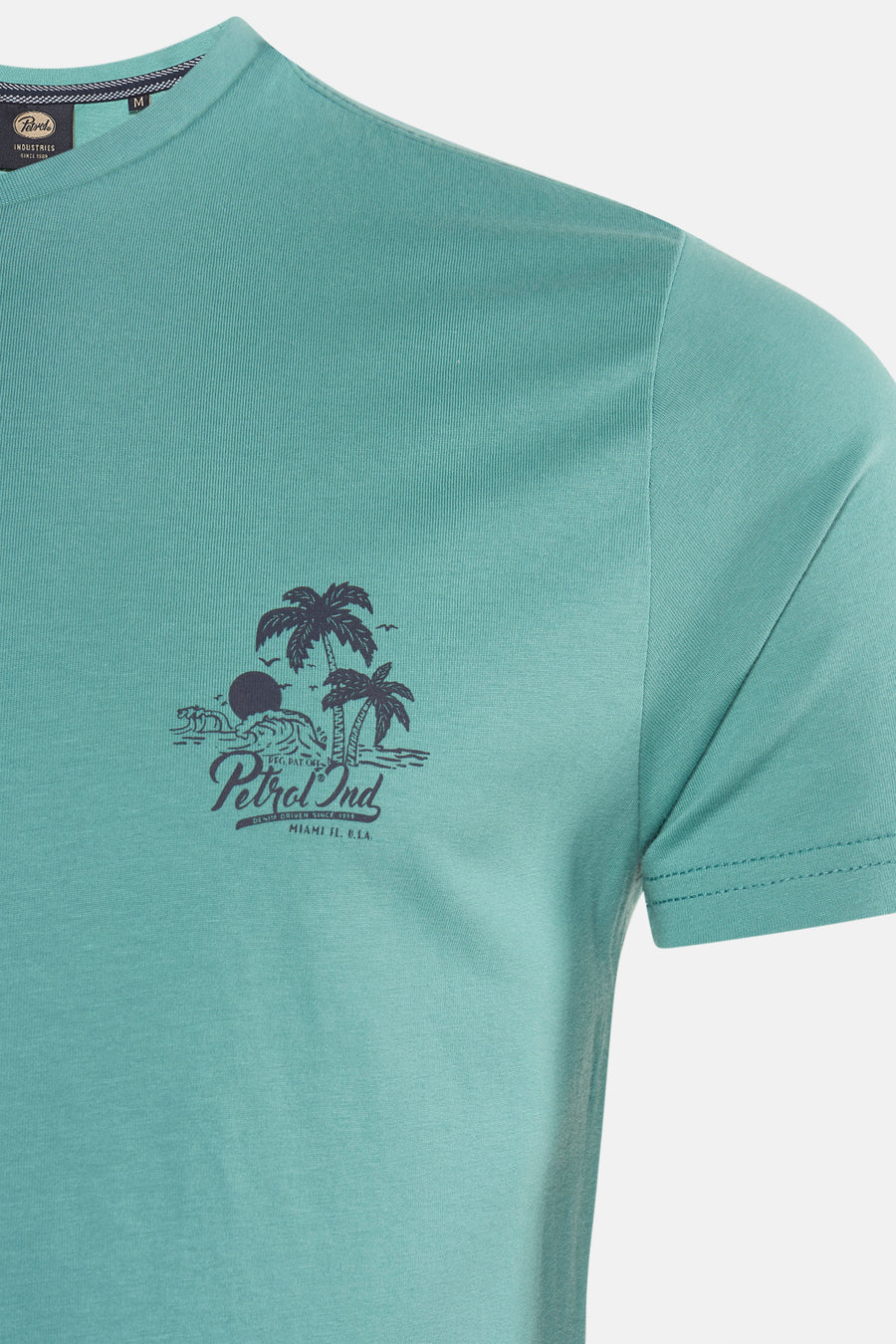 T-shirt vert à manches courtes de Petrol Industries, avec un imprimé palmier sur le devant.
