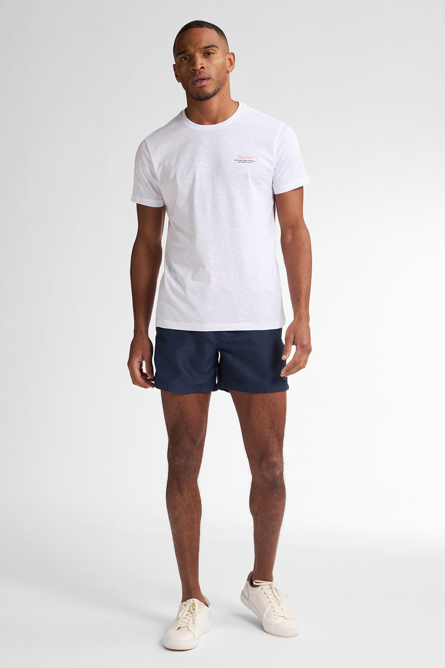 Wit T-shirt met korte mouwen van Petrol Industries, met een klein logo op de borst en gedragen met een marineblauwe korte broek.
