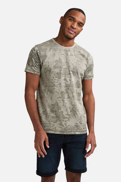 Groen T-shirt met korte mouwen van Petrol Industries, met een bladerpatroon en gedragen met een spijkerbroekshort.