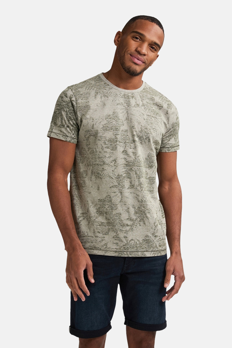 Groen T-shirt met korte mouwen van Petrol Industries, met een bladerpatroon en gedragen met een spijkerbroekshort.