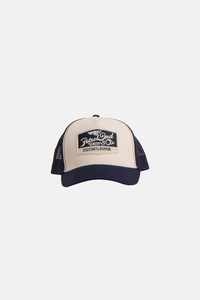 Blauwe pet van Petrol Industries, met beige inzetstuk en logopatch aan de voorkant.