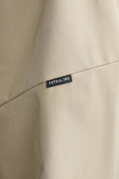 Veste courte beige de Petrol Industries, avec couture visible et étiquette noire de la marque.