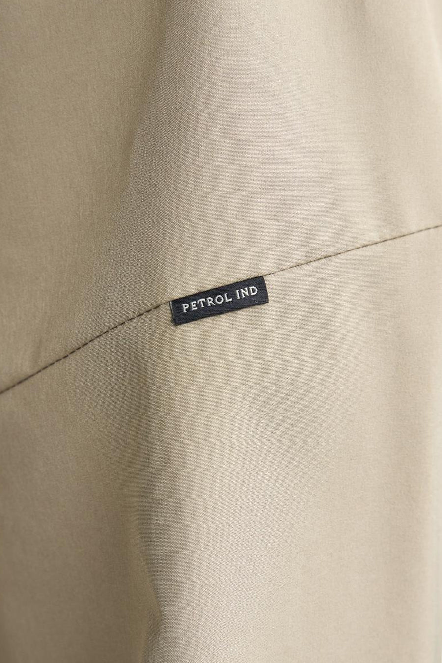 Veste courte beige de Petrol Industries, avec couture visible et étiquette noire de la marque.