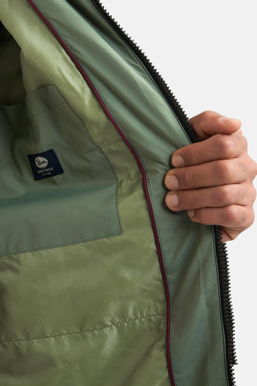 Lange kaki jas van Petrol Industries®, groene voering met binnenzak en zichtbare ritssluiting.