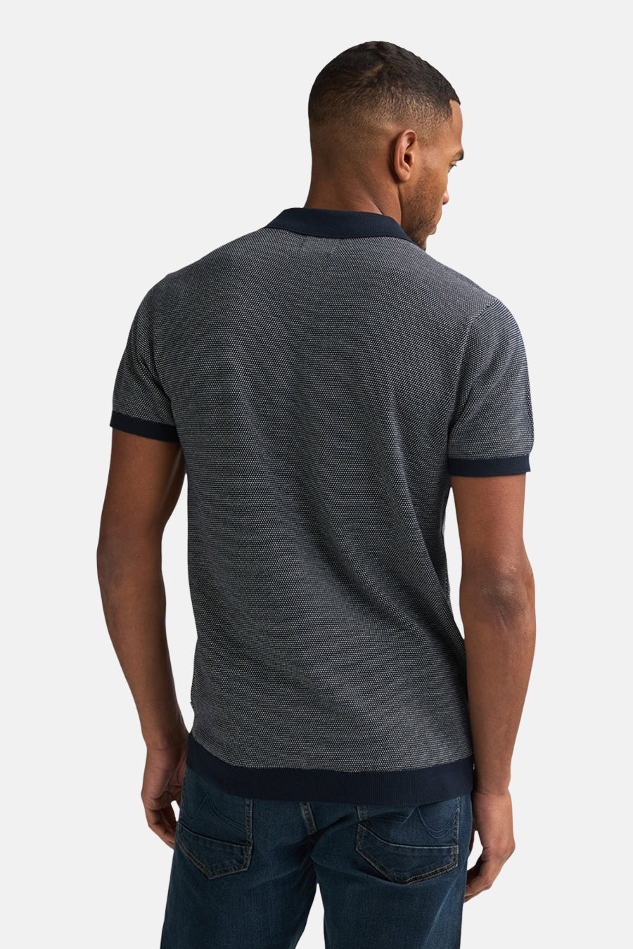 Pull bleu par Petrol Industries® avec motif texturé, col et manches courtes bleu marine, porté avec un jean.
