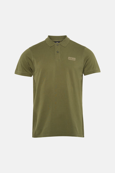 Groen poloshirt met korte mouwen van Petrol Industries®, gedragen met een spijkerbroek en witte sneakers.