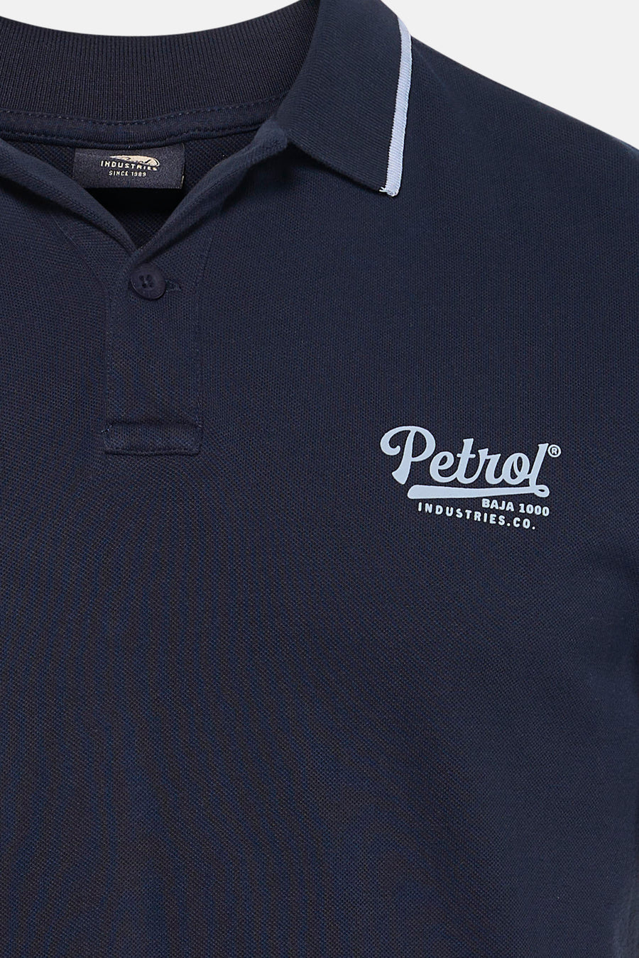 Blauwe polo met korte mouwen van Petrol Industries, met contrasterende kraag en logo op de borst.